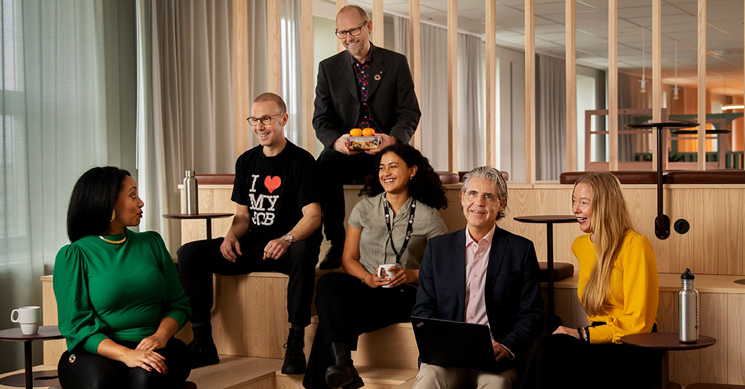 Sida team members chat during a lunch break in modern looking office